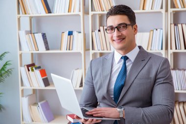 Kütüphanede çalışan bilgisayarlı bir iş adamı.
