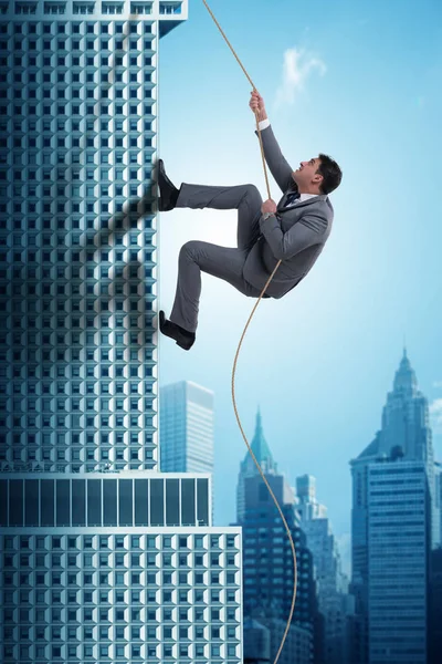 Empresário escalando arranha-céus em conceito de desafio — Fotografia de Stock