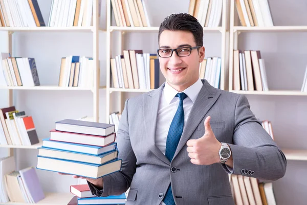 Étudiant en droit des affaires avec pile de livres travaillant en bibliothèque — Photo