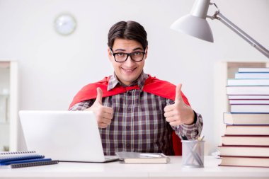 Dizüstü bilgisayarı olan süper kahraman öğrenci sınavlara hazırlanıyor.