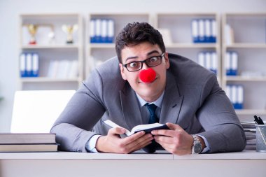 Ofiste çalışan palyaço işadamı.