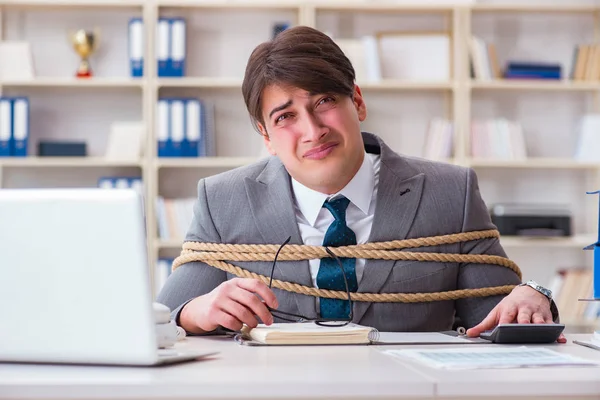 Бизнесмен связан веревкой в офисе — стоковое фото