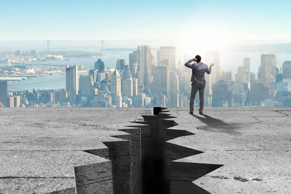 Businessman standing unsure next to cliff — Stock Photo, Image