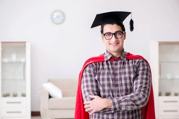 Super hjälte student bär kartong i en röd mantel — Stockfoto