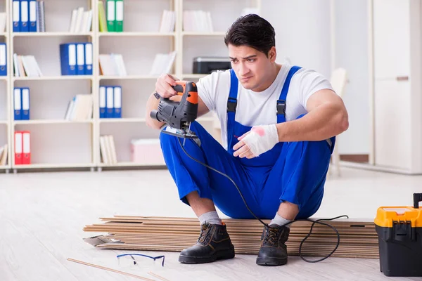 Trabajador joven que trabaja en baldosas laminadas piso — Foto de Stock