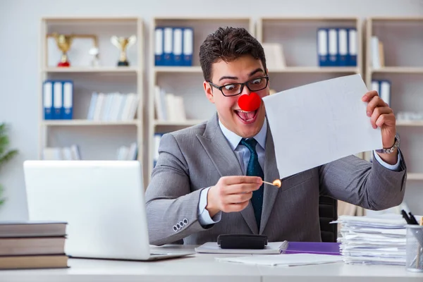 Clown homme d'affaires brûlant des papiers dans le bureau — Photo