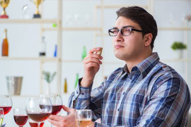 Profesyonel şarap garsonu kırmızı şarap tadıyor.