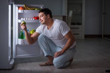 Buzdolabındaki adam gece yemek yiyor.