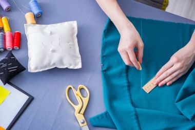 Kadın terzi dikiş dikmek için dikiş dikiyor.