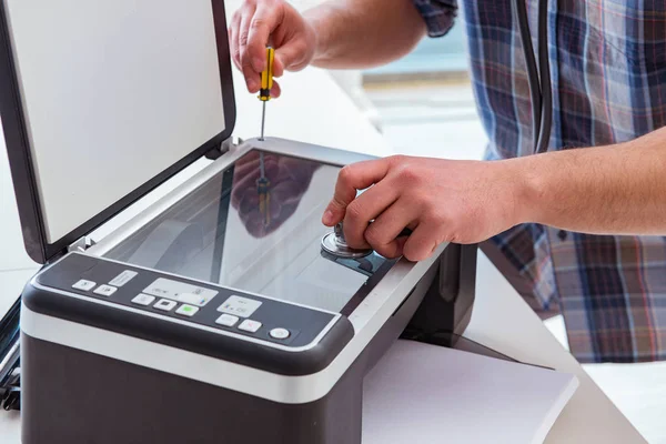 Tamirci bozuk renk yazıcısını tamir ediyor