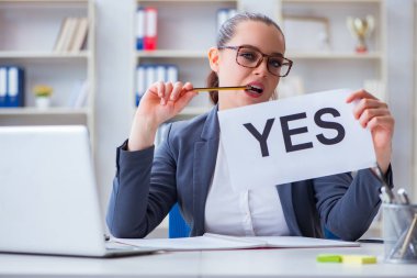 Ofisinde evet mesajı olan iş kadını.