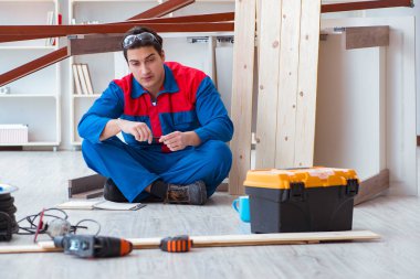 İnşaatta defter planlama yapan genç bir marangoz.