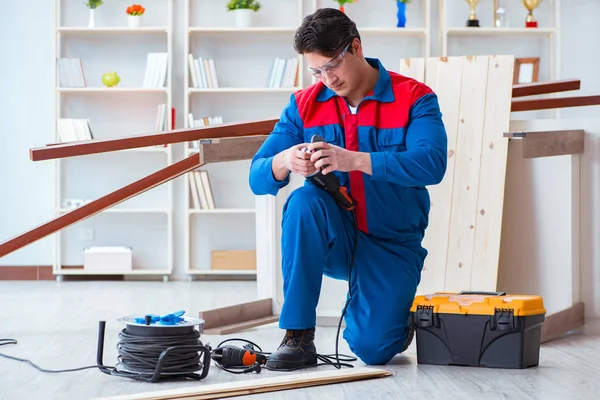 Genç marangoz ahşap kalaslarla çalışıyor.