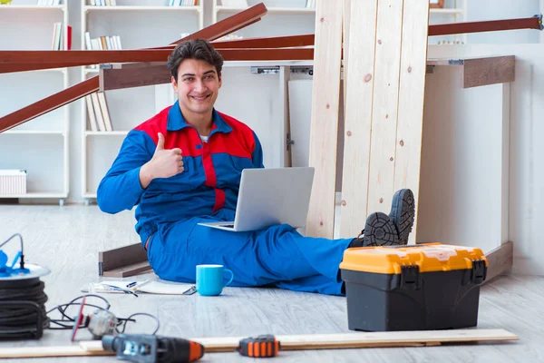 Dizüstü bilgisayarı olan genç bir marangoz