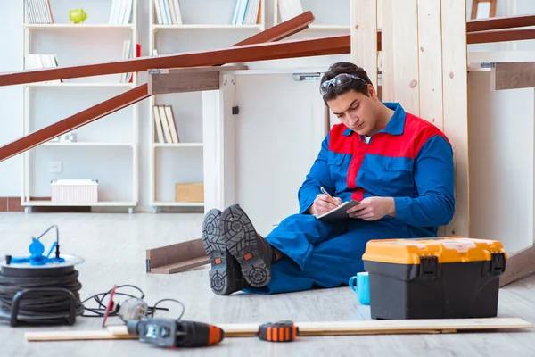 İnşaatta defter planlama yapan genç bir marangoz.