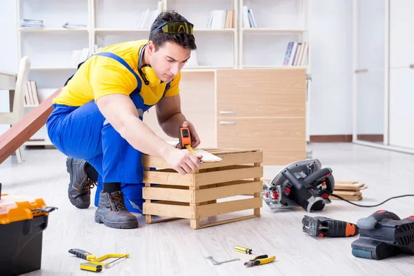 Tamirci marangoz tahta ve ölçü tahtasıyla çalışıyor.