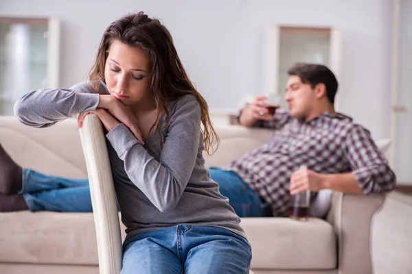 Genç bir aile kavramında içki sorunu yaşayan sarhoş bir koca.