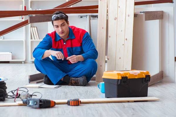 İnşaatta defter planlama yapan genç bir marangoz.