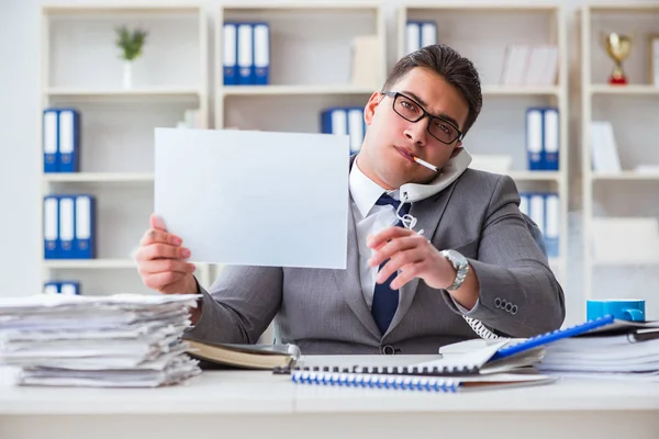 Empresário fumando no trabalho no escritório segurando uma mensagem em branco bo — Fotografia de Stock