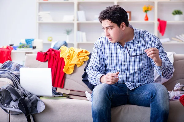 Genç adam dağınık bir odada çalışıyor.