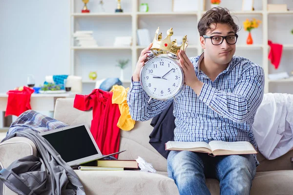 Genç adam dağınık bir odada çalışıyor.