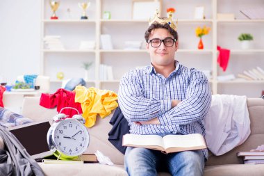 Genç adam dağınık bir odada çalışıyor.