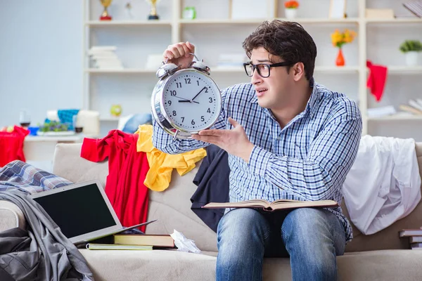 Genç adam dağınık bir odada çalışıyor.