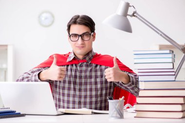 Dizüstü bilgisayarı olan süper kahraman öğrenci sınavlara hazırlanıyor.