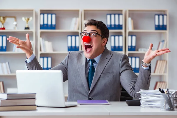 Ofiste çalışan palyaço işadamı.