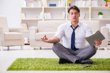 İş adamı ofiste yerde oturuyor.