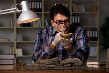 Arkeolog geç saatlere kadar ofiste çalışıyor.