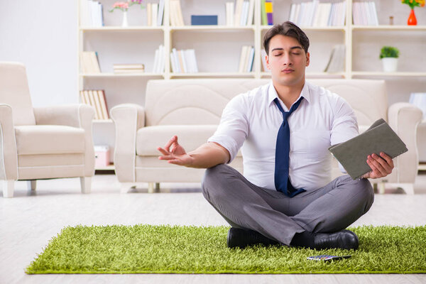 Бизнесмен, сидящий на полу в офисе