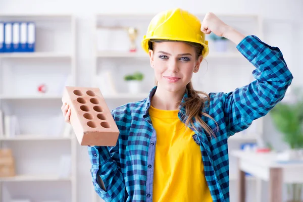 Mujer con ladrillo en concepto de construcción — Foto de Stock