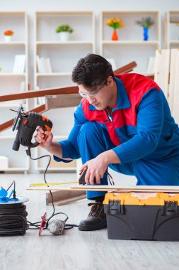 Genç marangoz ahşap kalaslarla çalışıyor.