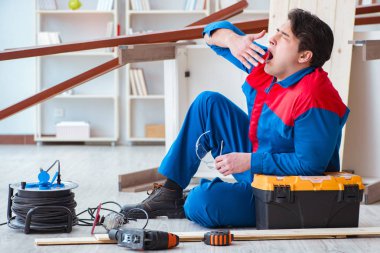 Genç marangoz ahşap kalaslarla çalışmaya ara veriyor.