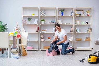 Adam evi temizliyor.