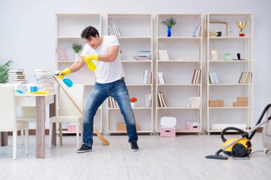 Adam evi temizliyor.