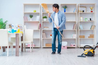 Adam evi temizliyor.