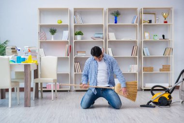 Adam evi temizliyor.