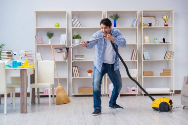 Adam evi temizliyor.