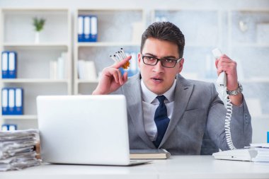 İşadamı ofisinde sigara içiyor.