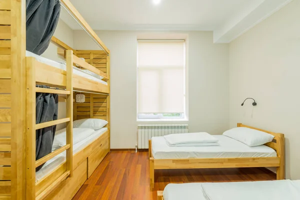 Hostel dormitory beds arranged in room — Stock Photo, Image