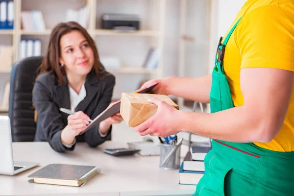 Postbode bezorgt pakketje op kantoor — Stockfoto