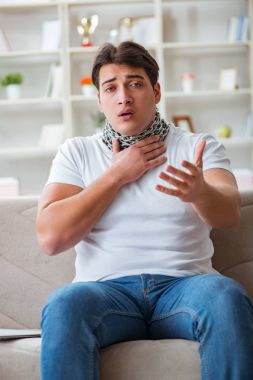 Genç adam boğaz ağrısı çekiyor.