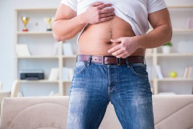 Diyet konseptinde fazladan ağırlık çeken adam.