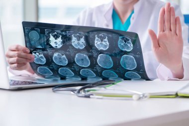 Doktor hastanede MRI görüntüsünü inceliyor.