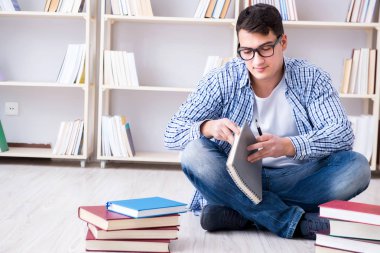 Genç öğrenci kitaplarla çalışıyor.