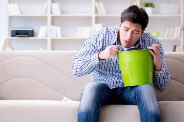 Midesi bulanan ve kusan bir adam.