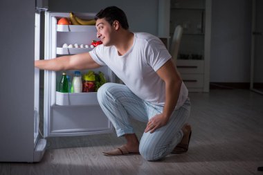 Buzdolabındaki adam gece yemek yiyor.