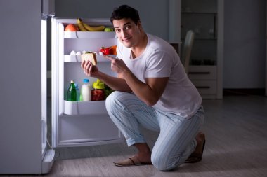 Buzdolabındaki adam gece yemek yiyor.